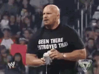 A Man Is Holding A Microphone In Front Of A Crowd With A W Logo On The Bottom Right Corner GIF
