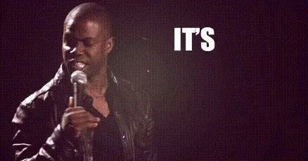 A Man Is Holding A Microphone In Front Of A Sign That Says `` It 'S About To Go '' GIF