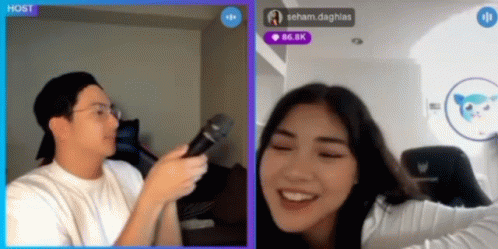 a man is holding a microphone in front of a woman who is smiling in a video chat