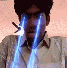 A Man Is Holding A Pair Of Scissors In His Mouth And His Eyes Are Glowing In Blue Light . GIF