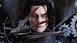 A Man Is Holding A Pair Of Scissors With Blood On Them . GIF