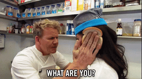 A Man Is Holding A Piece Of Bread Over A Woman 'S Face And Asking Her What Are You . GIF