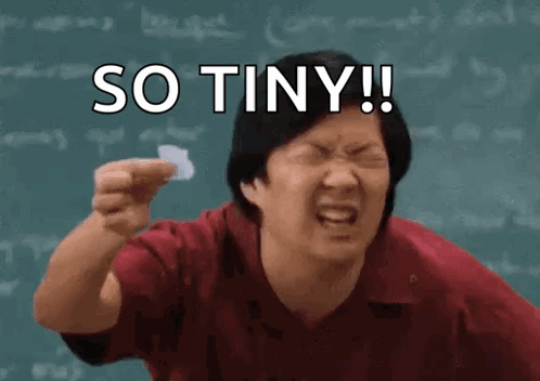 A Man Is Holding A Piece Of Paper In Front Of A Blackboard With The Words So Tiny Written On It . GIF