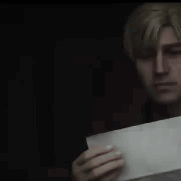 a man is holding a piece of paper in his hand and looking at it .