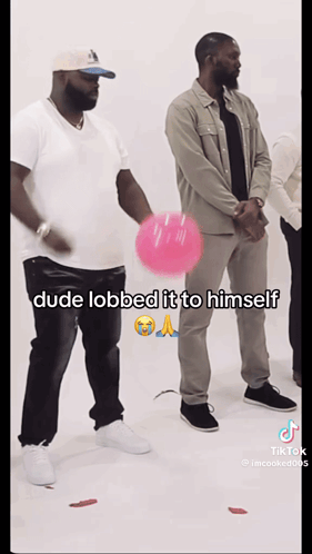 A Man Is Holding A Pink Balloon And Says Dude Lobbed It To Himself On The Bottom GIF