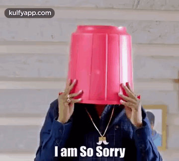 A Man Is Holding A Pink Bucket On His Head . GIF