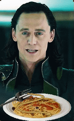 A Man Is Holding A Plate Of Spaghetti With A Fork In His Mouth GIF
