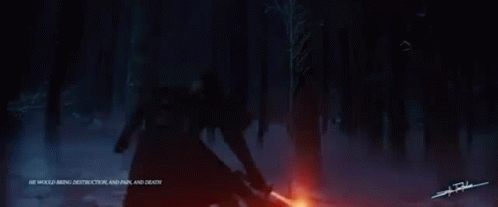 A Man Is Holding A Red Lightsaber In The Dark . GIF