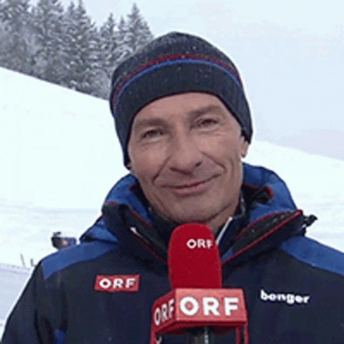 A Man Is Holding A Red Orf Microphone In Front Of Him GIF