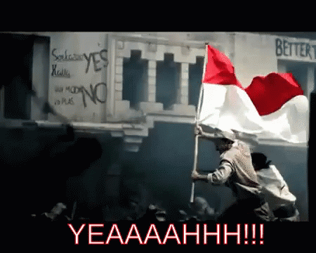 A Man Is Holding A Red White And Blue Flag In Front Of A Sign That Says Better GIF