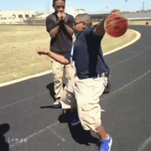 A Man Is Holding A Spalding Basketball In His Hands GIF