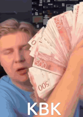 A Man Is Holding A Stack Of 500 Bills In His Hand GIF