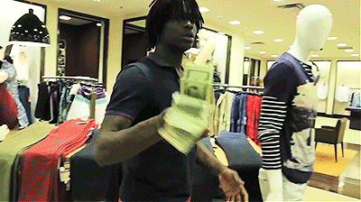 A Man Is Holding A Stack Of Money In A Store GIF