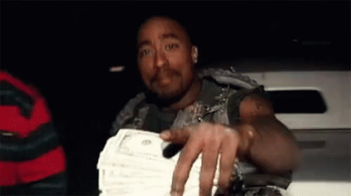 A Man Is Holding A Stack Of Money In His Hand While Sitting In A Car . GIF