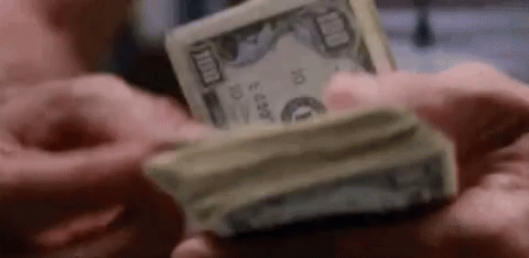A Man Is Holding A Stack Of Money In His Hands . GIF