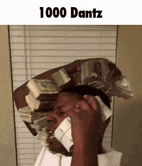 A Man Is Holding A Stack Of Money On His Head While Talking On A Cell Phone . GIF