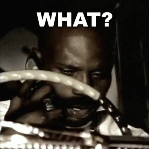 A Man Is Holding A Steering Wheel With The Words What Written On It GIF