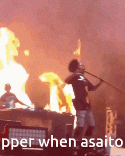 A Man Is Holding A Stick In Front Of A Fire With The Words " Pper When Asaito " Written Below Him GIF