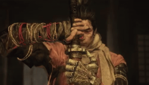 A Man Is Holding A Sword With A Rope Around His Wrist GIF