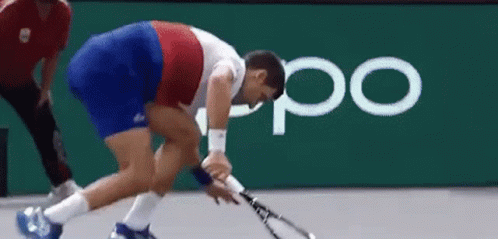 A Man Is Holding A Tennis Racquet On A Court In Front Of An Oppo Logo . GIF