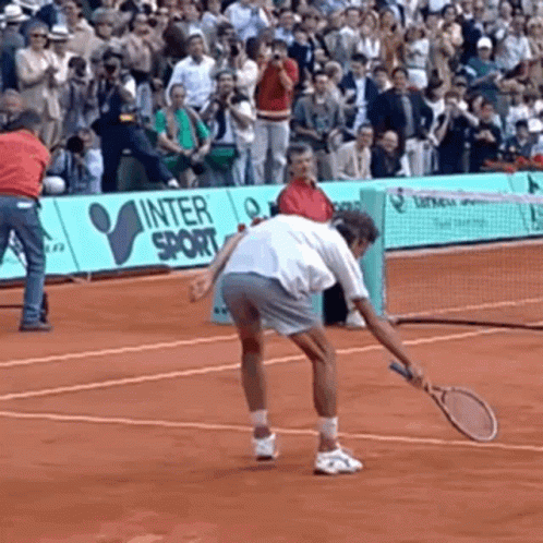 A Man Is Holding A Tennis Racquet On A Tennis Court In Front Of A Sign That Says Inter Sport GIF