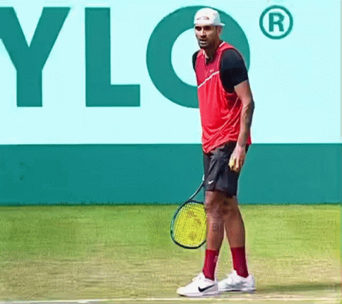 A Man Is Holding A Tennis Racquet On A Tennis Court In Front Of A Sign That Says Ylg GIF