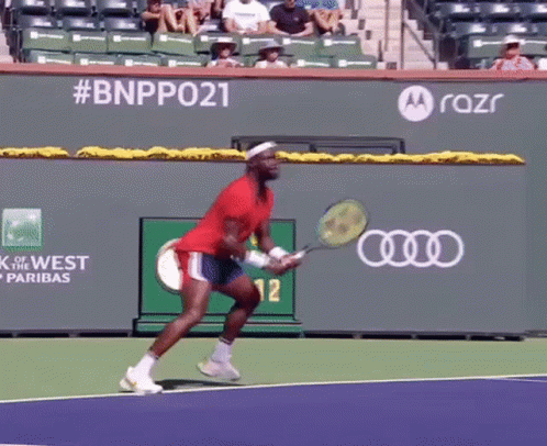 a man is holding a tennis racquet on a tennis court with a motorola logo in the background