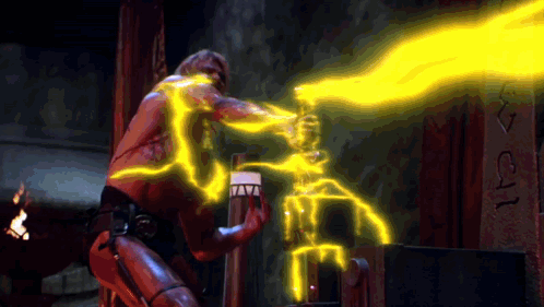 A Man Is Holding A Torch With A Flame Coming Out Of It And The Letters I And J Are On The Wall GIF