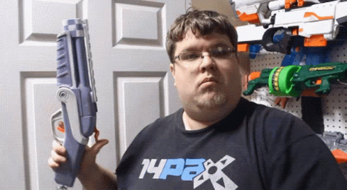 A Man Is Holding A Toy Gun And Wearing A Shirt That Says 14Pax GIF