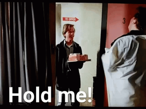 A Man Is Holding A Tray With A Cake On It In Front Of A Door . GIF