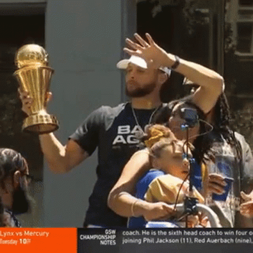 A Man Is Holding A Trophy And Wearing A Shirt That Says Ac GIF