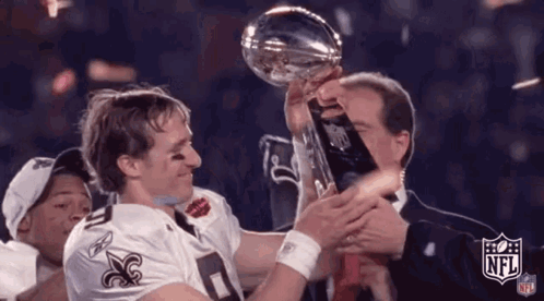 A Man Is Holding A Trophy In His Hands While A Man In A Suit Holds A Trophy . GIF