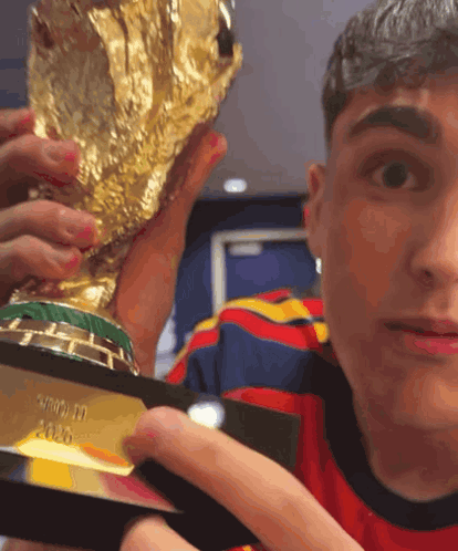 a man is holding a trophy that says ' fifa ' on it