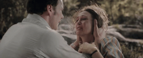 A Man Is Holding A Woman 'S Face While She Is Crying And Covering Her Ears . GIF
