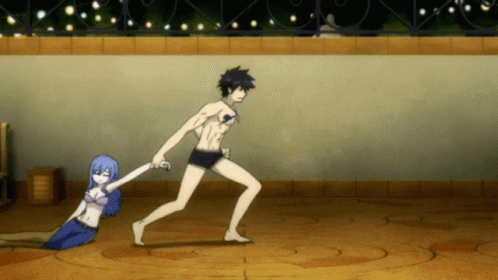 A Man Is Holding A Woman 'S Hand While She Lays On The Ground GIF