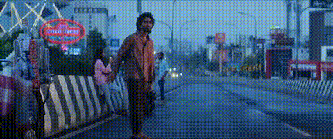 A Man Is Holding A Woman 'S Hand While Standing On The Side Of A Street . GIF