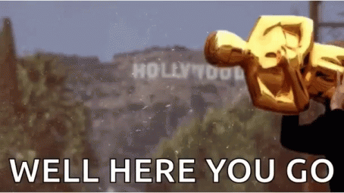 A Man Is Holding An Oscar Statue In Front Of A Sign That Says Hollywood GIF