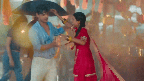 A Man Is Holding An Umbrella Over A Woman 'S Head . GIF