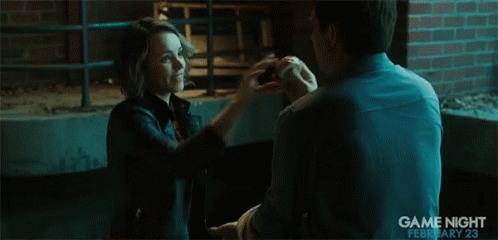 A Man Is Holding Another Man 'S Hand In A Scene From Game Night GIF