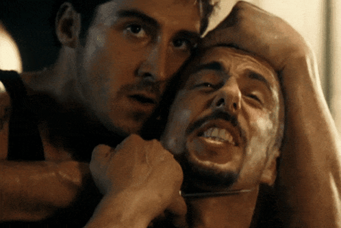 A Man Is Holding Another Man 'S Neck With His Hand GIF