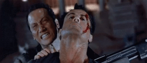 A Man Is Holding Another Man 'S Neck With His Mouth Open While Holding A Gun . GIF