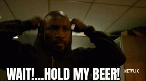 A Man Is Holding His Hands To His Ears And Says Wait Hold My Beer GIF