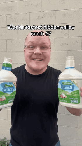 a man is holding two bottles of ranch dressing
