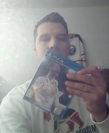 A Man Is Holding Up A Fifa 18 Video Game For Ps4 GIF