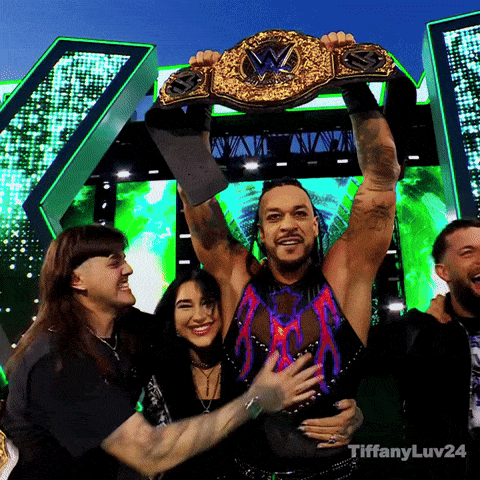 A Man Is Holding Up A Wrestling Championship Belt With Tiffanyluv24 Written Below Him GIF