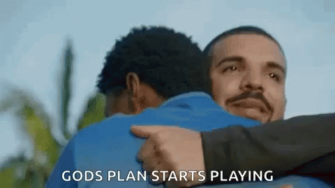 A Man Is Hugging Another Man With The Words `` Gods Plan Starts Playing '' Written On It . GIF