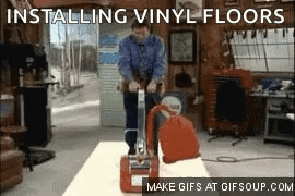 A Man Is Installing Vinyl Floors With A Machine GIF