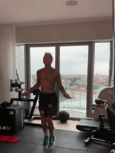 A Man Is Jumping A Jump Rope In A Gym With A Box That Says 50 On It GIF