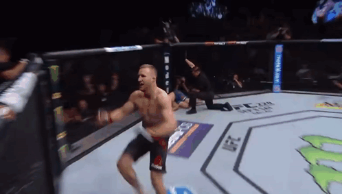 A Man Is Jumping In The Air In A Boxing Ring GIF