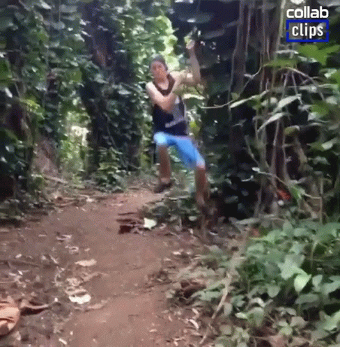 A Man Is Jumping In The Air In A Jungle With A Collab Clips Logo In The Corner GIF